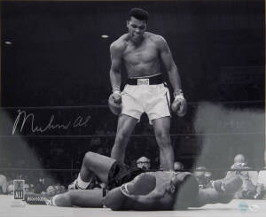 MUHAMMAD ALI, signed b/w photograph of Ali standing over Sonny Liston, size 51x41cm. With 'Online Authentics' No.OA-8090306.
