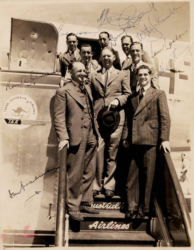 1948 AUSTRALIAN TEAM, original photograph (16x20cm) showing 8 members of the team boarding a TAA aircraft, with 8 signatures - Don Bradman, Sam Loxton, Lindsay Hassett, Ian Johnson, Doug Ring, Bill Johnston, Neil Harvey & Ron Hamence.
